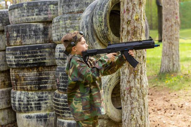 istock Boy weared in camouflage playing laser tag in special forest playground. 1488598283