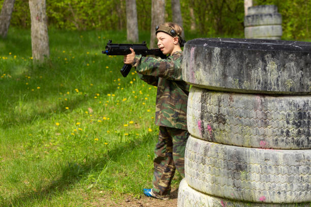 istock Boy weared in camouflage playing laser tag in special forest playground. 1488598368