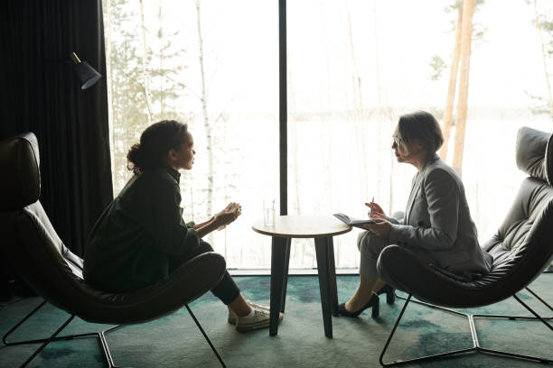 istock Young female patient and mature professional psychologist discussing problems 1488604162