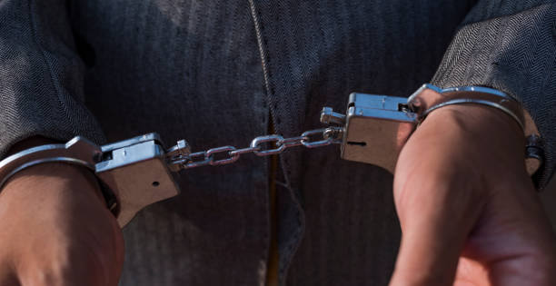 istock Businessman arrested for corruption. Man in a suit with handcuffs on his hands. 1488605470