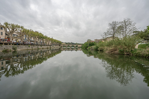 View of the Sommieres Roman bridge reflecting in the Vidourle river