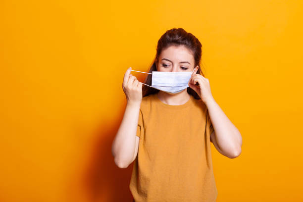 istock Caucasian woman putting protective mask on face 1488610698