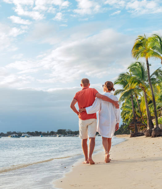 istock Couple in love hugging while walking on a sandy exotic beach. They have an evening walk by Trou-aux-Biches seashore on Mauritius island. People relationship and tropic honeymoon vacations concept 1488610727