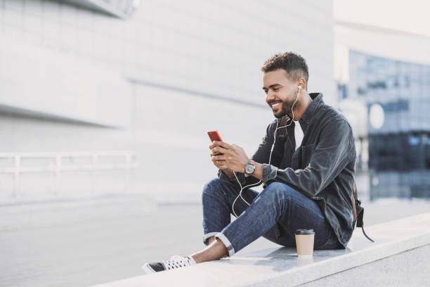 istock Happy man using smart phone in a city 1488611063