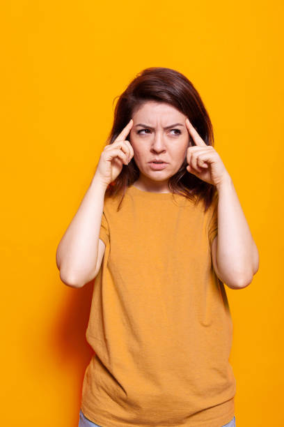 istock Pensive woman thinking about idea with fingers on temples 1488611246