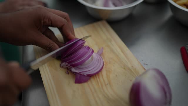 Woman's hand chopping onions at cooking class