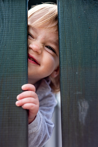 a cute little girl on the playground hid and peeked out
