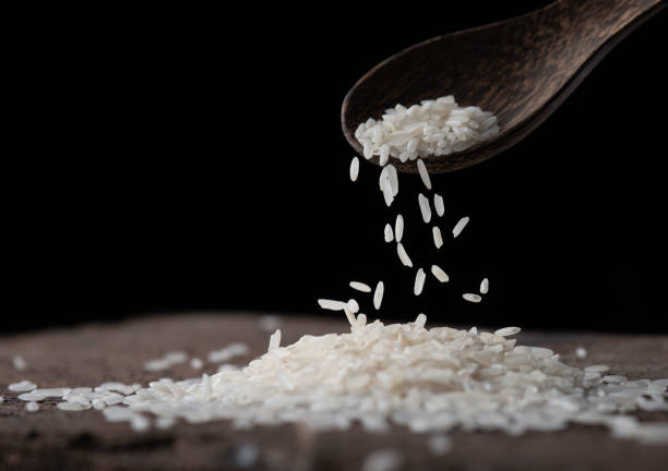 istock Rice with wooden spoon on wood texture 1488613640