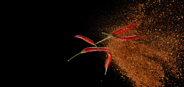 Red pepper powder explosion isolated on black background,Flying red pepper,Motion blur