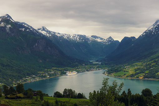Dramatic landscape of the mountains with viewpoint of dramatic fjord with cruise and a town in Stryn, Vestland county