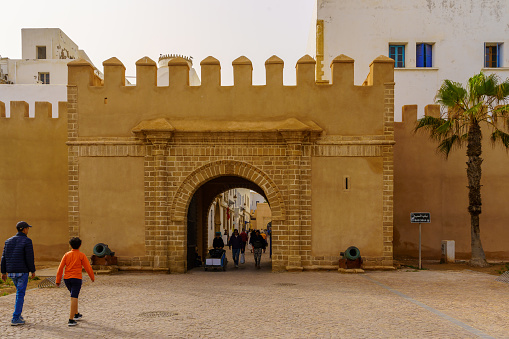 Essaouira, Morocco - April 06, 2023: View of the Bab Sbaa gate, in the walls of the medina, with locals and visitors, in Essaouira (Mogador), Morocco