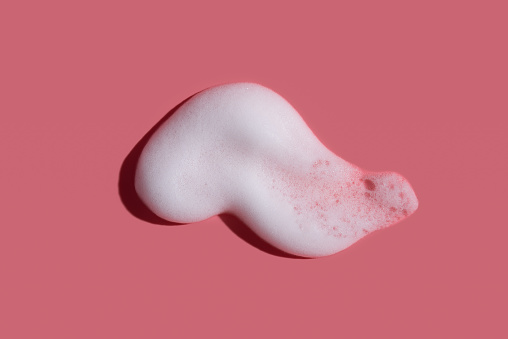 hite soap foam, suds of detergent, cleaning gel or shampoo on pink backdrop