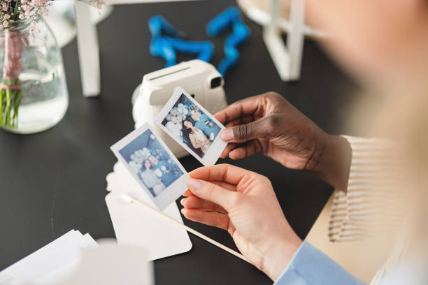 istock Female Hands Holding Polaroid Photos That Are Still Developing During A Party 1488615679
