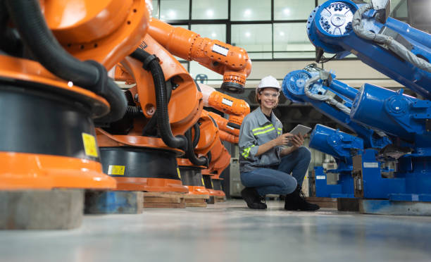 istock A female engineer installs a program on a robotics arm in a robot warehouse. And test the operation before sending the machine to the customer. 1488620564