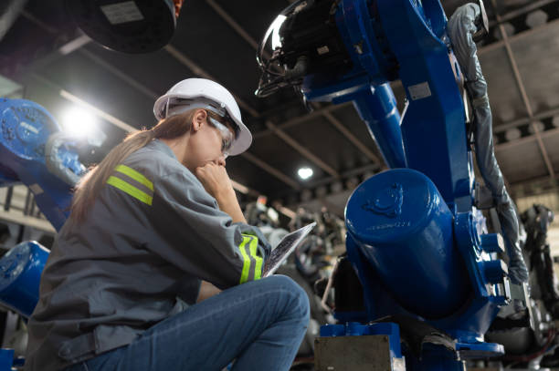 istock A female engineer installs a program on a robotics arm in a robot warehouse. And test the operation before sending the machine to the customer. 1488620683
