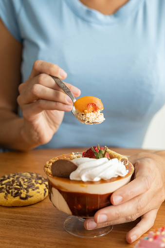 enjoying a delicious sweet dessert decorated with various toppings, cake and cookies in the background, wallpaper in a food studio, gourmet pastries