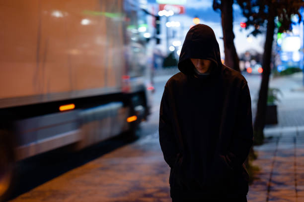 밤의 도시에서 검은 후드티를 입은 얼굴 없는 남자 - hood 뉴스 사진 이미지