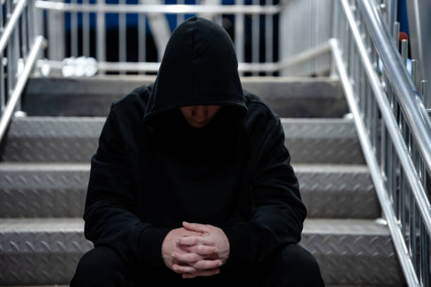 istock Depressed young man with a black hoodie during the night 1488622529