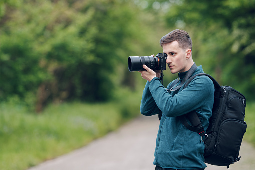 Traveler taking photos with a mirrorless camera in nature
