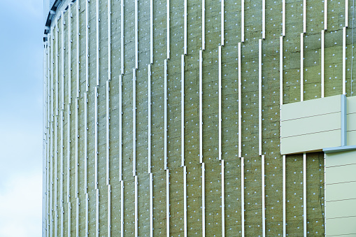 Insulation and installation of siding on a round building