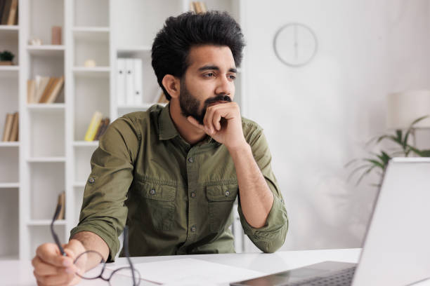 istock Tired Indian man takes off glasses, suffers from painful sensations, has problems with astigmatism. A man stressed after a long working day at the computer relieves the pain in his eyes. 1488624776