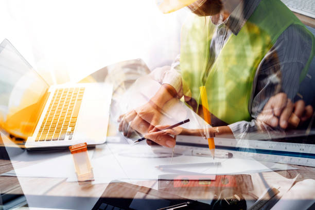 istock engineer working at a drawings of house in office for discussing. Engineering tools and construction concept. 1488628122