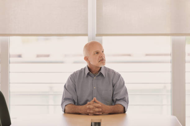 istock Elderly man sitting waiting looks up and away 1488629209