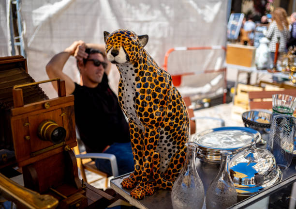 The weekend flea market on the city square in Cannes, France.  Vendors bring their merchandise of all types for sale at the weekend market.   The market is popular with tourist and residents alike.