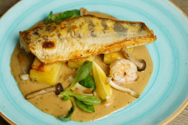 Roasted Zander fish fillet with potatoes and mushroom sauce