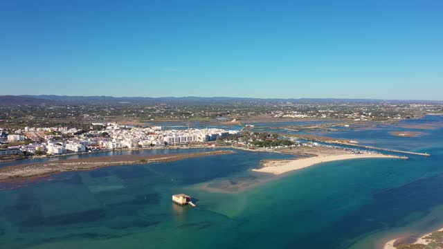 Aerial view. Drone flight over the natural Portuguese park Ria formosa over the village of Fuseta. Rescue house in the middle of a bay with turquoise water