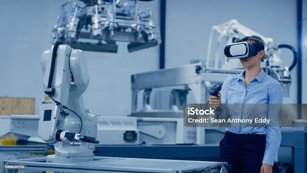 Engineering, robotics and woman in vr glasses and joystick for ai, futuristic electronics and manufacturing in industry 4.0. Robot design, workshop and technician person in virtual reality of machine Industry Stock Photo