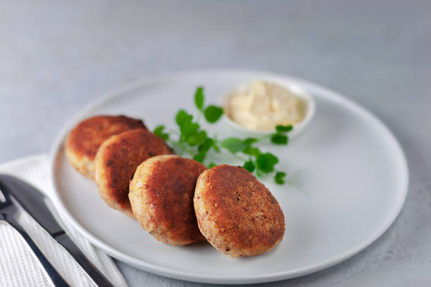 istock Fish cutlets with mayonnaise on a white plate. 1488636783