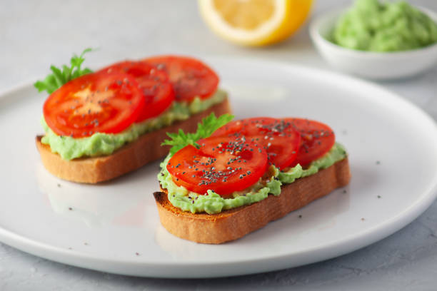 istock Vegan sandwich with avocado and tomatoes on a white dish 1488636860