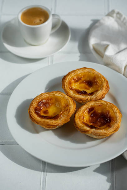 istock Fresh traditional Portuguese pasteis de nata and espresso on white background. 1488637906