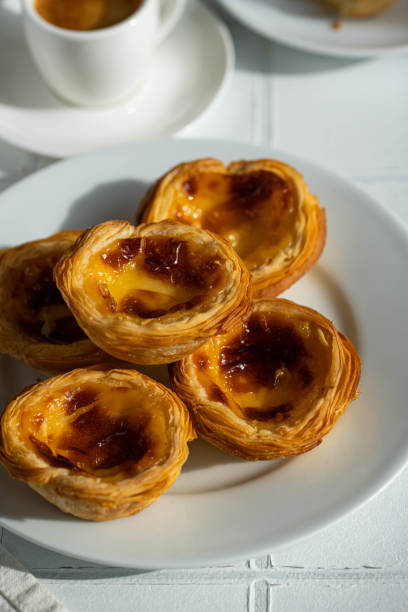 istock Fresh traditional Portuguese pasteis de nata and espresso on white background. 1488637909
