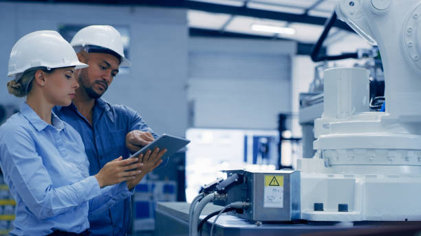 istock Engineering, tablet and man and woman in lab with machine for analysis, research and maintenance. Technology, collaboration and engineer team on digital tech for robotic, equipment and software 1488640258