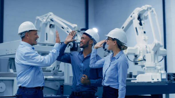 Engineering, high five and people for robotics manufacturing in teamwork, success or celebration in industry 4.0. Group of technician or woman and men hands together for machine or electronics design