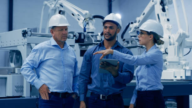 istock Automation, tablet and men and woman in engineering lab on machine for analysis, research and discussion. Technology, collaboration and engineer team on digital tech for robot, equipment and software 1488640879