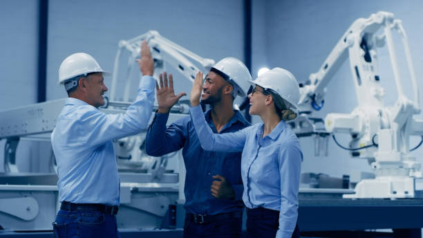 istock High five, robotics and engineering people with factory teamwork, success or celebration in industry 4.0 design. Diversity group of technician, woman and men hands together for machine or electronics 1488640882