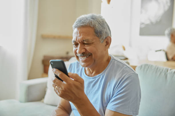 istock Senior man relax on couch with smartphone, communication and texting on mobile app with social media. Happy male person at home, retirement and browse internet with chat on online website and smile 1488642246