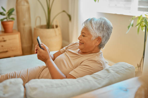 istock Senior woman relax on sofa with smartphone, communication and texting on mobile app with social media. Elderly female person at home, retirement and browse internet, chat on online website with smile 1488642367