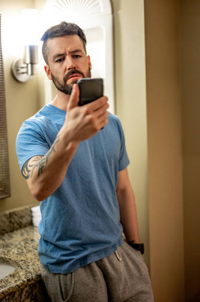 istock Man at home looks at his cell phone with concern, bad news or problems 1488642594