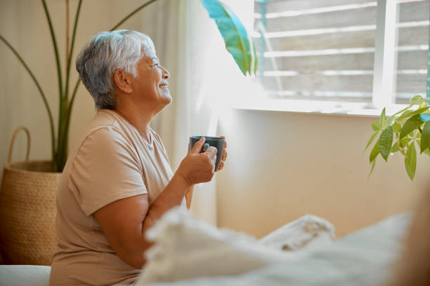 Morning coffee, senior woman at home with gratitude and mindfulness waking up in bed. Relax, old female and retirement of a elderly person with tea, self love and me time thinking of a memory