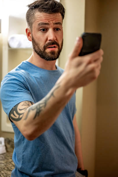istock Man at home looks at his cell phone with concern, bad news or problems 1488642760