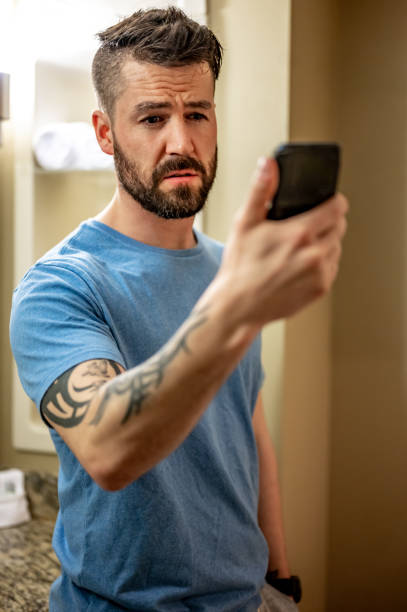istock Man at home looks at his cell phone with concern, bad news or problems 1488642762
