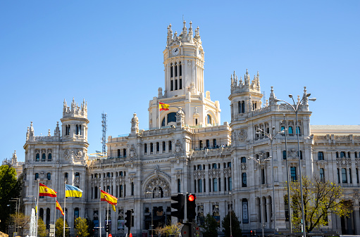 Cybele Palace (Palacio de Cibeles), the grand city hall of Madrid with a Spanish flag blowing in the wind