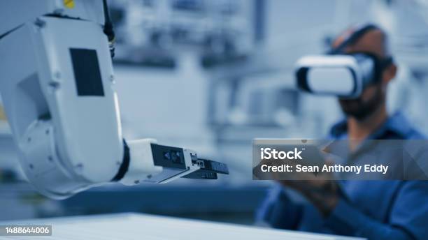 Engineering Robot Arm And Man With Vr Glasses And Tablet For Ai Futuristic Electronics And Manufacturing Industry 40 Robotics Workshop Of Technician Person In Digital Virtual Reality And Machine Stock Photo - Download Image Now