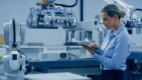 Woman, tablet and research for robotic engineering, automation or ai development with advanced technology. Female engineer working with tech and industrial machinery for machine learning or control