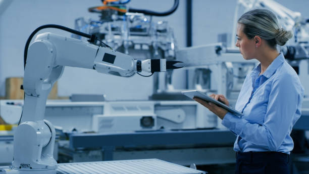 istock Woman, tablet and machine learning with robot arm for engineering, robotic automation or ai development. Female engineer working on technology for industrial machinery or innovation at the warehouse 1488644404
