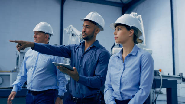 istock Engineering, tablet and people in meeting in lab with machine for analysis, research and automation. Point, teamwork and men and woman engineers on digital tech for robotic ai, equipment and software 1488644409